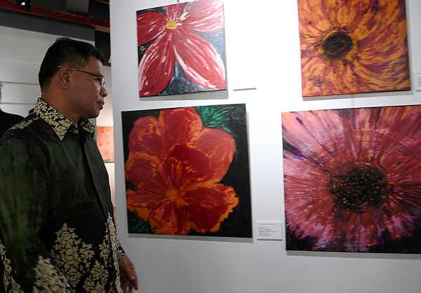 Domestic Trade and Consumer Affairs Minister Datuk Seri Saifuddin Nasution Ismail looks at the paintings on display at the the launch of the art exhibition by Badariah Abdul Hamid at the Oasis Village in Petaling Jaya on March 2, 2019. — Bernama