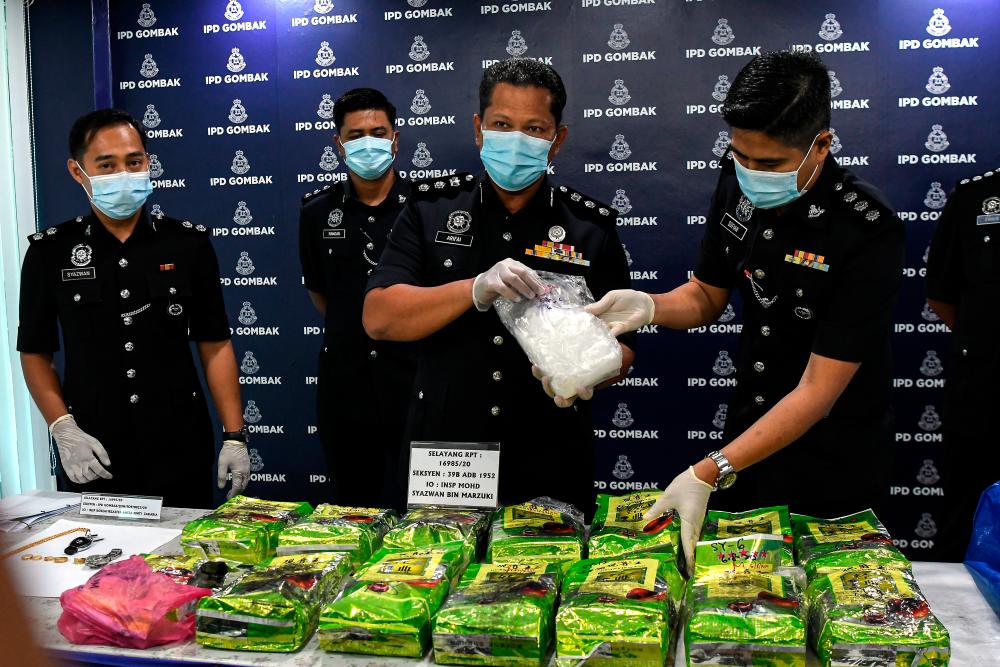 Gombak district police chief ACP Arifai Tarawe (2nd from R) displays 14 packages of suspected syabu worth RM560,000 seized in a raid in the parking lot of a supermarket in Batu Caves, Selangor last Thursday, at a press conference at Gombak district police headquarters today. - Bernama
