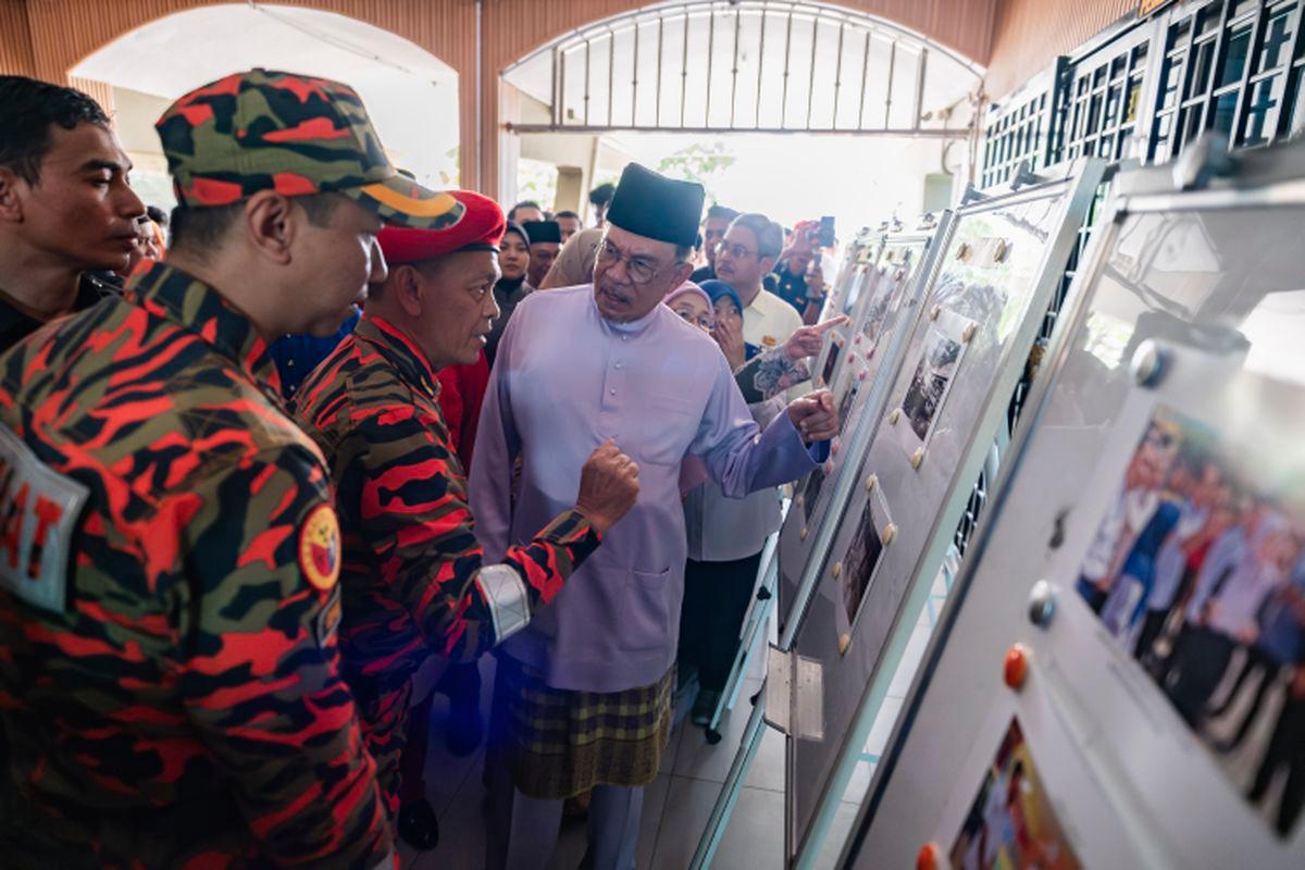 Perdana Menteri, Datuk Seri Anwar Ibrahim berbual dengan Pengarah JBPM Kuala Lumpur, Hassan 'As'ari Omar (dua, kiri) ketika meninjau bangunan pentadbiran Sekolah Menengah Sains Alam Shah, Cheras yang musnah dalam kebakaran, hari ini. - fotoBERNAMA