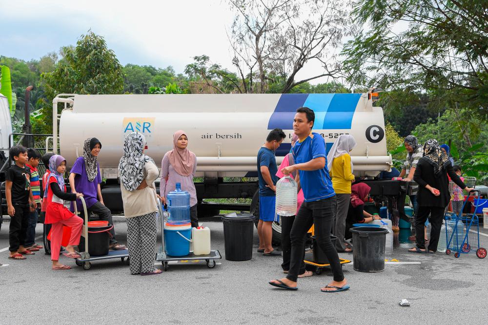 Some residents of the Sri Tanjung apartments at USJ 8, Subang queue for a turn to take water from the Air Selangor water truck, due to the water supply disruption. - Bernama
