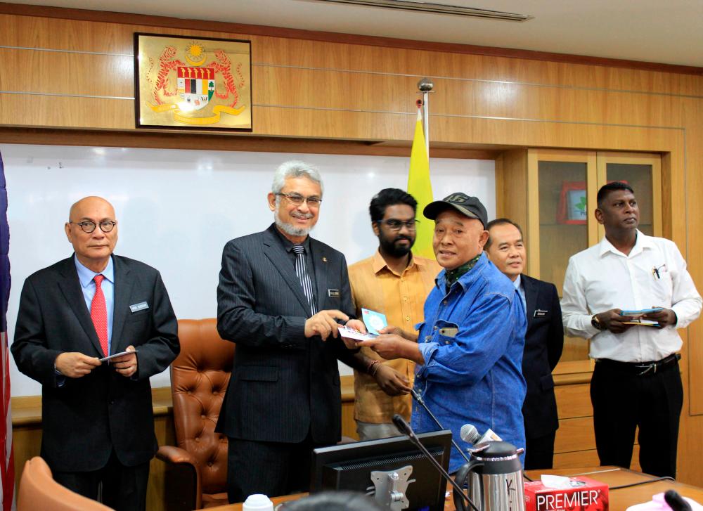 Federal Territory Minister Khalid Abdul Samad (2nd from L) presents donations to 19 victims of the Sentul Market on Dec 31 at the DBKL building today. - Bernama