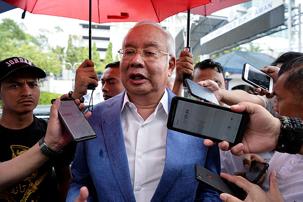 Former prime minister Datuk Seri Najib Abdul Razak speaking to the press after exiting Bukit Aman Police Headquarters today. — Bernama