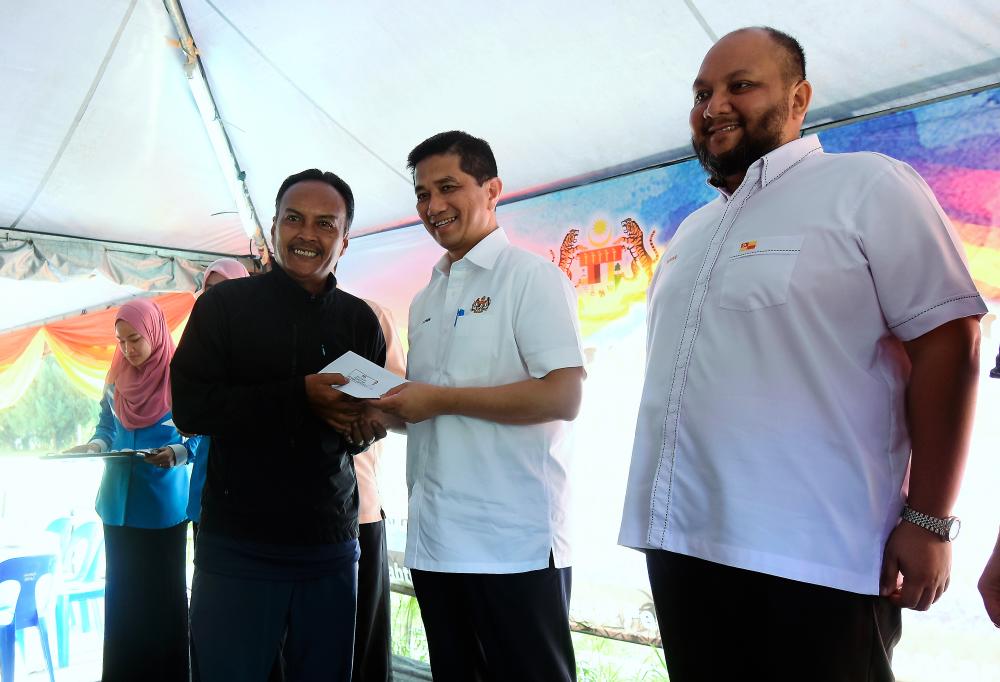 Economic Affairs Minister Datuk Seri Mohamed Azmin Ali (c) hands over assistance to a resident of Taman Keramat Permai in a ceremony and closing of the evacuation centre at MPAJ Multi-purpose Hall at AU2 on May 4, 2019. - Bernama