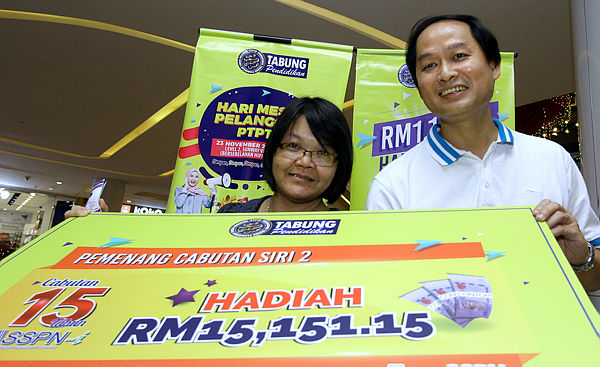 Winner of the SSPN-i Draw Lim Pee Ping (left) and Koh Yok Keong (right) shows the amount of their winnings at the PTPTN office in Kuala Lumpur today — Bernama