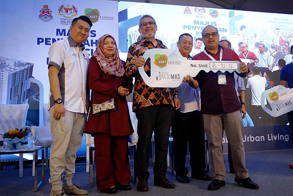 Federal Territories Minister Khalid Abd Samad (C) holds up a replica key with a homeowner at the Residensi JalilMas, Bukit Jalil on March 2, 2019. — Bernama
