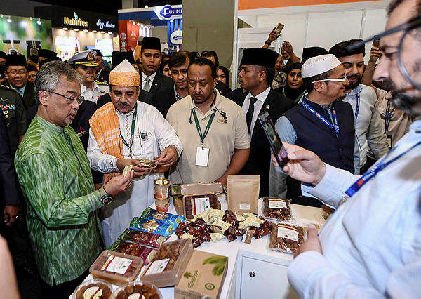 The Agong samples some halal products during a visit to Mihas on April 5, 2019. — Bernama