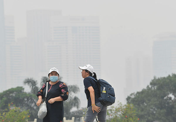 A local visitor wears a face mask due to the haze in Taman Tasik Perdana today. — Bernama