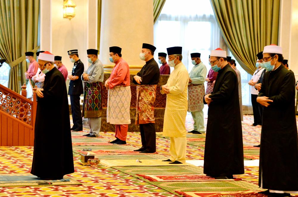 The Yang di-Pertuan Agong Al-Sultan Abdullah Ri’ayatuddin Al-Mustafa Billah Shah (C) performs Aidilfitri prayers at the main surau of the Istana Negara, on May 24, 2020. — Bernama