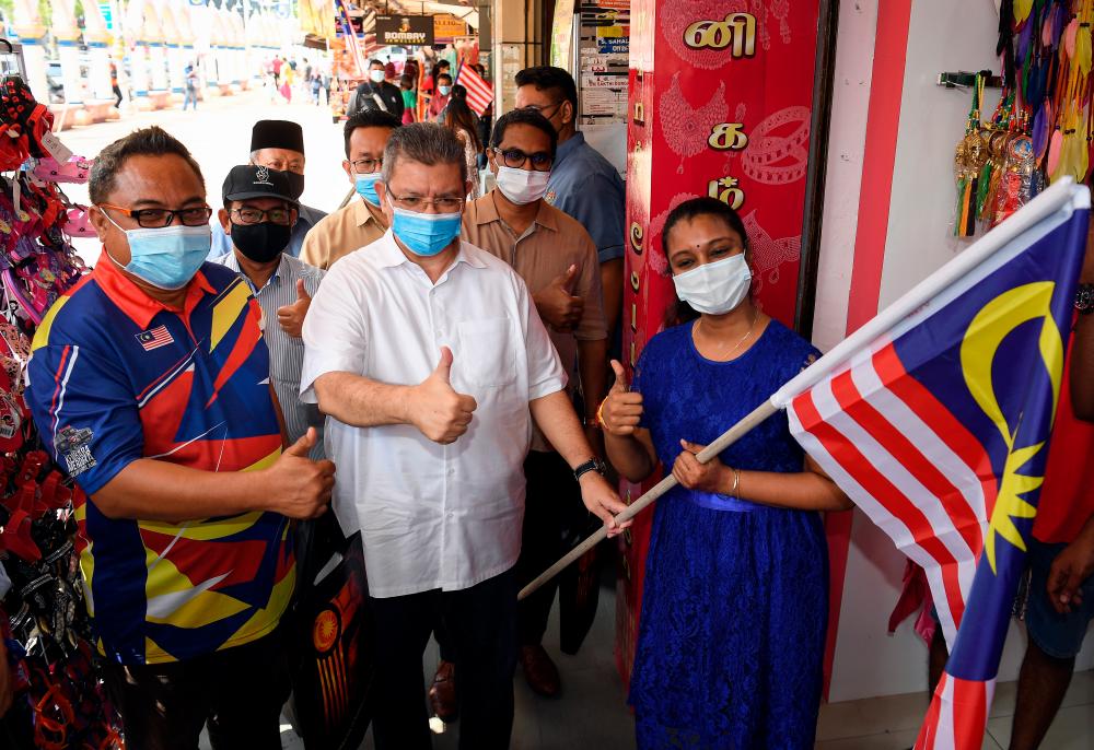 Communications and Multimedia Minister Datuk Saifuddin Abdullah (C) during the distribution of Jalur Gemilang in a walkabout session in Little India in Brickfields, Jalan Pasar in the Pudu Area, and Kampung Baru Mosque Kuala Lumpur. — Bernama