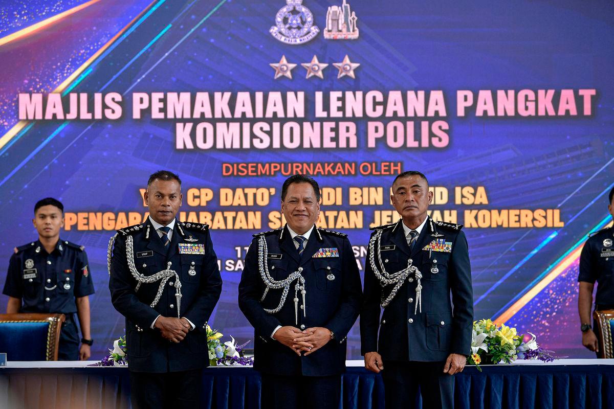 Pengarah Jabatan Siasatan Jenayah Komersil (JSJK) Datuk Rusdi Mohd Isa (dua, kanan) ketika sesi pemakaian lencana pangkat kepada Ketua Polis Kuala Lumpur yang baharu Datuk Fadil Marsus (kanan) - fotoBERNAMA