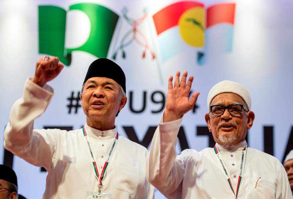 Umno president Datuk Seri Ahmad Zahid Hamidi (L) and PAS president Datuk Seri Abdul Hadi Awang pose for a picture after signing the charter to formalise their political cooperation, at the Putra World Trade Centre, on Sept 14, 2019. — Bernama