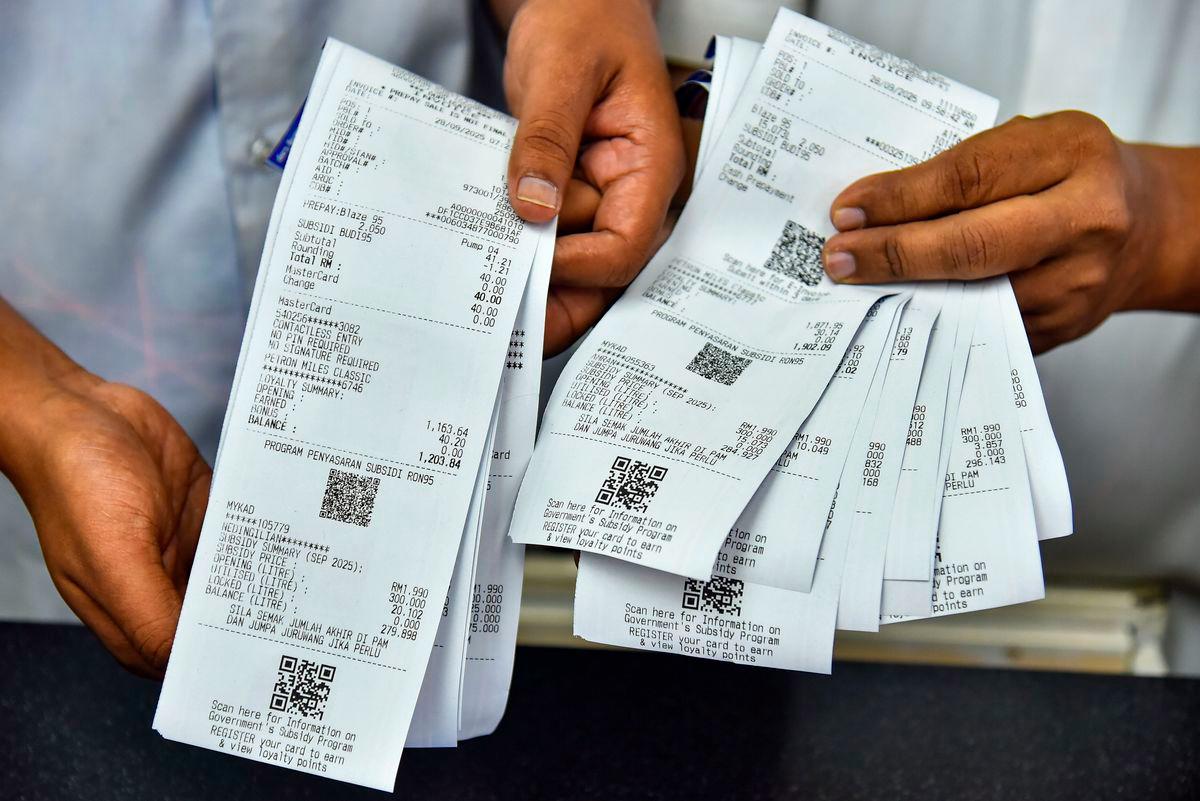 A Petron petrol station employee displays a receipt for the purchase of subsidised RON95 petrol at the price of RM1.99 per litre, compared to the current market price of RM2.05 per litre, made by a subsidy recipient today. – BERNAMA