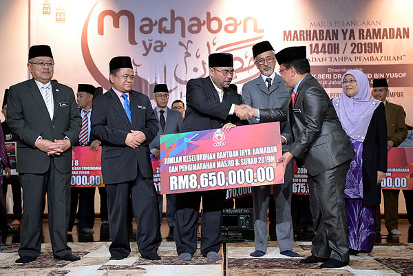 Minister in the Prime Minister’s Department Datuk Seri Dr Mujahid Yusof Rawa (3rd from L) hands over a cheque to Federal Territory Islamic Religious Department (JAWI) chief Ajib Ismail (2nd from R). — Bernama