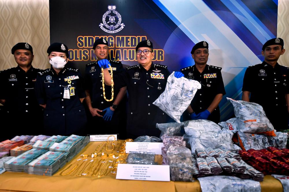 Kuala Lumpur police chief Commissioner Datuk Seri Mazlan Lazim (3rd from R) displays off some of the seized loot at a press conference at Kuala Lumpur contingent police headquarters today. - Bernama