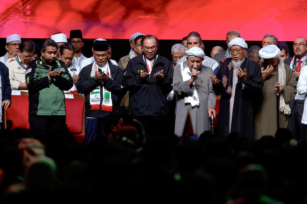 Perdana Menteri Datuk Seri Anwar Ibrahim mengaminkan doa ketika bacaan Qunut Nazilah semasa Himpunan Solidariti Bersama Gaza di Stadium Axiata Arena, Bukit Jalil semalam- BERNAMA