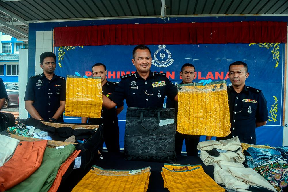 PETALING JAYA, 13 Okt -- Ketua Polis Daerah Petaling Jaya ACP Mohamad Fakhrudin Abdul Hamid (tengah) menunjukkan antara barang rampasan pada sidang media kejayaan tangkapan sindiket curi pakaian berjenama dan kes curi kabel di Ibu Pejabat Daerah Petaling Jaya hari ini. fotoBERNAMA