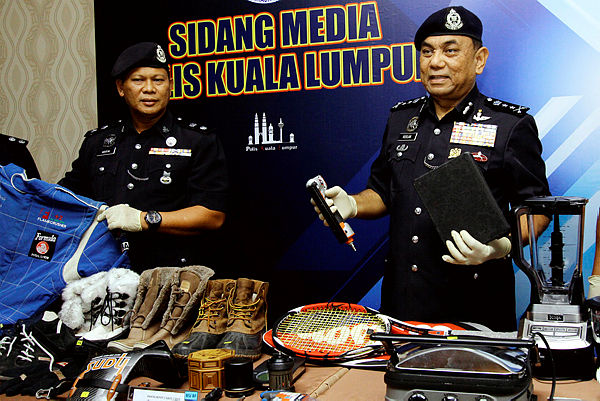 Kuala Lumpur acting police chief DCP Roslan Bek Ahmad (R) and Brickfields deputy police chief Supt Arifai Tarawe (L) display some of the stolen goods at a press conference at the Kuala Lumpur police headquarters. — Bernama