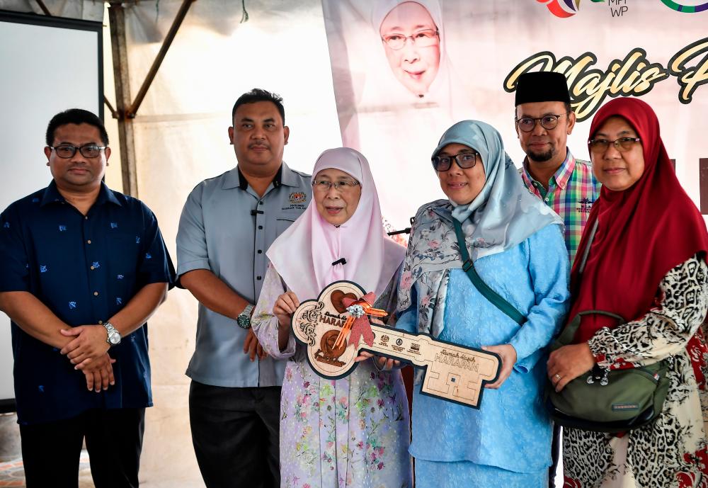 KUALA LUMPUR, Oct 21 -- The Prime Minister’s wife Datuk Seri Dr Wan Azizah Wan Ismail who is also the Member of Parliament for Bandar Tun Razak (three, left) handed over a replica of the key to the recipient, Azlina Hamzah, 48 (three, right) at the Rumah Kasih Key Handover Ceremony Hope at Lorong Mewah 7 Bandar Tun Razak today. BERNAMAPIX