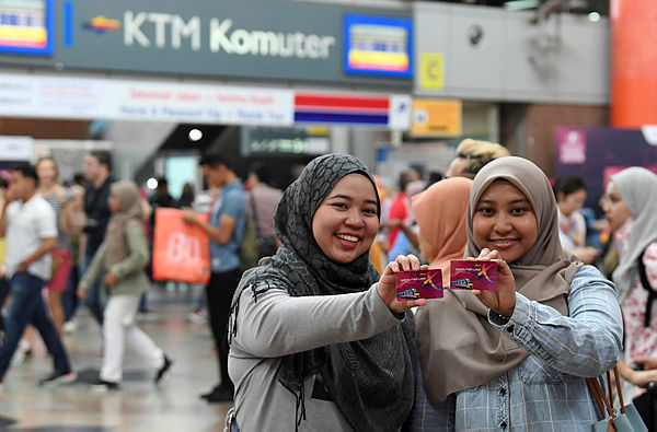 Students of Hazirah Zolkifly (L) and Aqilah Ismail show off their KTM Komuter Xtra20 discount card at KL Sentral on March 31, 2019. — Bernama