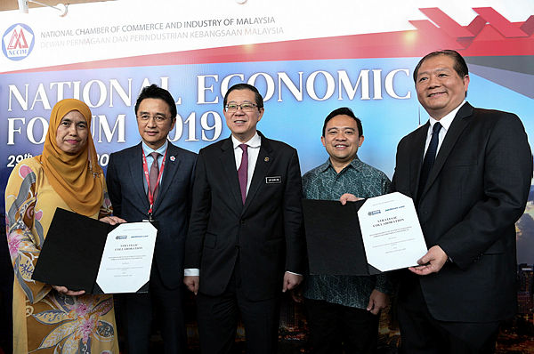 Finance Minister im Guan Eng, together with PTPTN chairman Wan Saiful Wan Jan (two, right) during an agreement exchange with JobStreet.com country manager Gan Bock Herm at Kuala Lumpur Convention Centre today. — Bernama