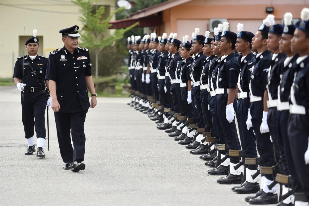 Inspector-General of Police Datuk Seri Hamid Bador (L) examines recruits on the parade ground at the 21st National Police Cadet Corps closing ceremony at the Bina Semangat Camp in Kuala Kubu Bharu today. - Bernama