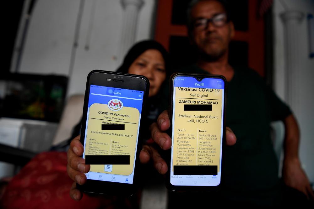 A couple showing their proper vaccination digital certification after receiving two doses of vaccine - Bernama