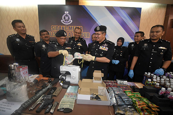 Kuala Lumpur Police Chief Datuk Seri Mazlan Lazim (4th from R) shows off the lingerie that was believed to be used by drug mules that were seized in a raid, during a press conference at Kuala Lumpur police headquarters on Jan 29, 2018. — Bernama