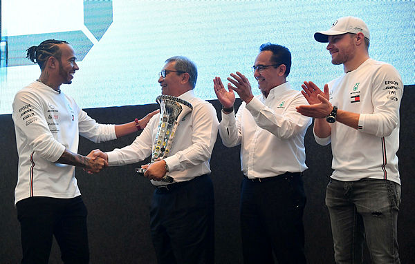 British Formula One Driver Lewis Hamilton (left) hands over a trophy to Petronas chairman Datuk Ahmad Nizam Salleh (second, left) and President and Group Chief Executive Officer Tan Sri Wan Zulkiflee Wan Ariffin (second, right) during the Petronas Celebrates Sixth F1 World Championship Win With Hamilton, Bottas event at KLCC today. — Bernama