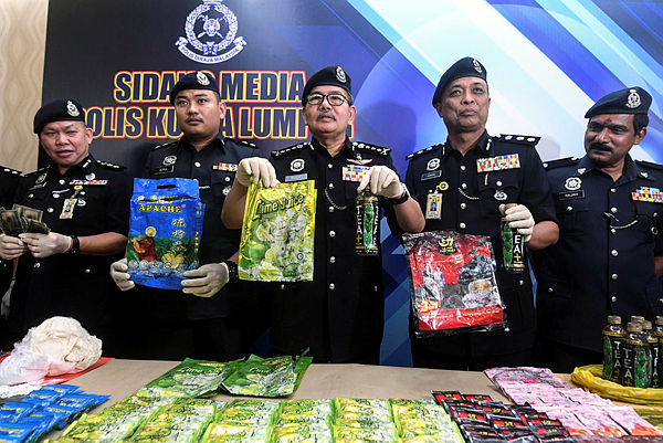 Kuala Lumpur police chief Comm Datuk Seri Mazlan Lazim (C) reveals items seized after a press conference on ‘Black Money’ fraud syndicates at the Kuala Lumpur police headquarters today. — Bernama