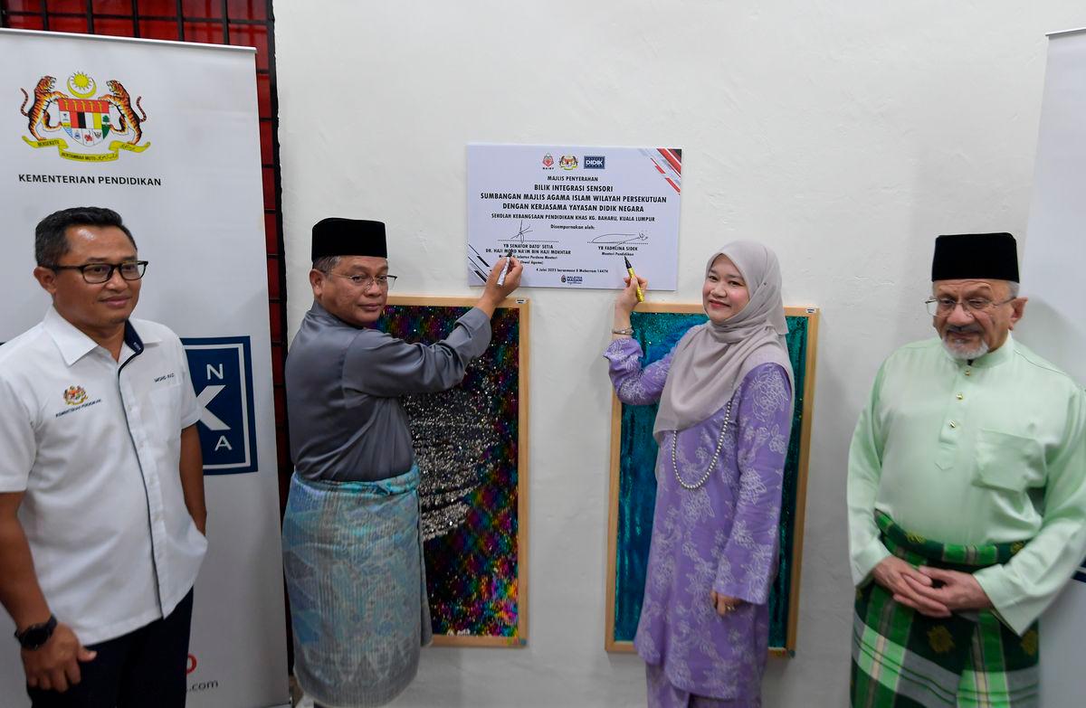Menteri di Jabatan Perdana Menteri (Hal Ehwal Agama) Datuk Dr Mohd Na’im Mokhtar bersama Menteri Pendidikan Fadhlina Sidek menandatangan plak perasmian pada Majlis Pelancaran Program Makanan Tambahan (PMT) Pelajar Menengah dan Bilik Multisensor di Sekolah Kebangsaan Pendidikan Khas Kampung Baharu - BERNAMA