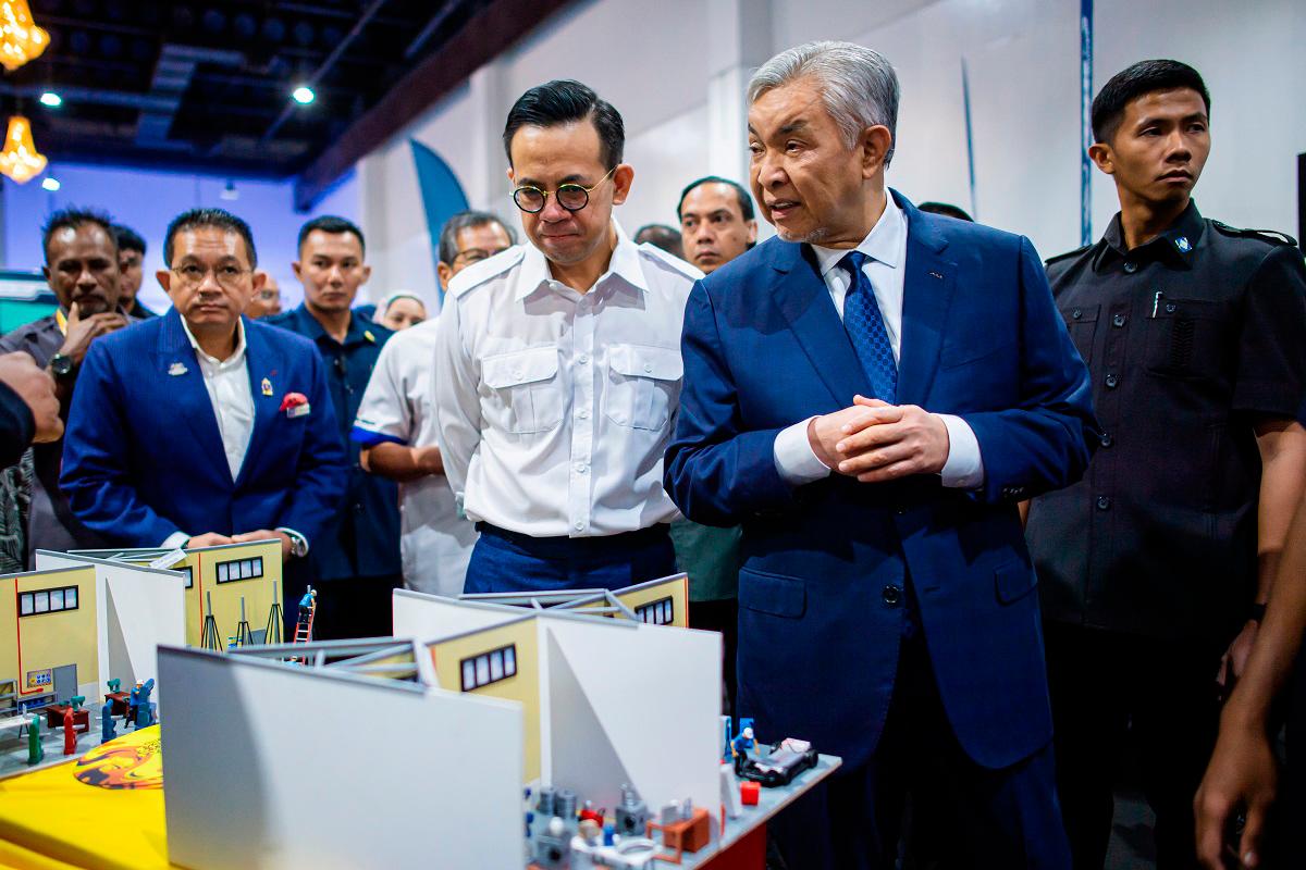 Ahmad Zahid and Sim visit an exhibition after the conference yesterday. – BERNAMApix