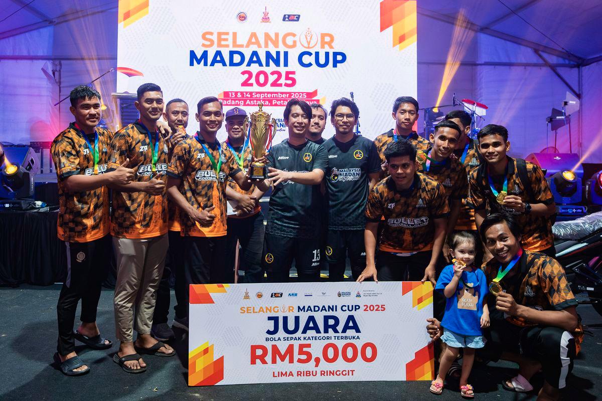 Deputy Minister of Youth and Sports, Adam Adli Abdul Halim (centre) presents the trophy to Bullet FC, the champions of the open football category at the 2025 MADANI Football Cup State-level Championship in Selangor, held at Padang Astaka today. Also present was the Political Secretary to the Minister of Finance, Muhammad Kamil Abdul Munim (centre, fifth from left). - BERNAMA