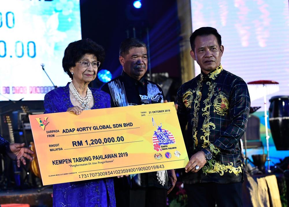 Tun Dr Siti Hasmah Mohamad Ali (L) received a donation from 4orty Global Sdn Bhd Adap chairman Datuk Daud Pengiran Prince (R) during the 2019 Warriors Fund Campaign Charity Dinner at Wisma Perwira on the night of Oct 21, 2019. - Bernama