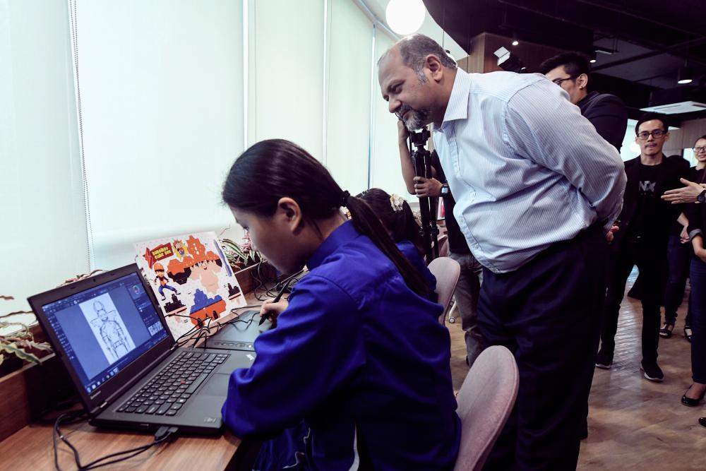 Communications and Multimedia Minister Gobind Singh Deo looks at the work of students of the Kre8tif @School programme. - Bernama