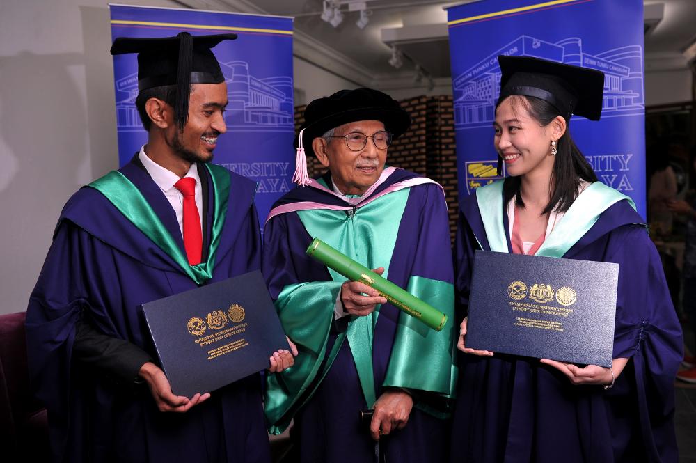 Tun Daim Zainuddin poses for a photo with two other graduates, Muhammad Madhi Mohd Budiman (L) and Lau Win Yei (R), during University Malaya’s 59th Convocation Ceremony, on Oct 12, 2019. — Bernama