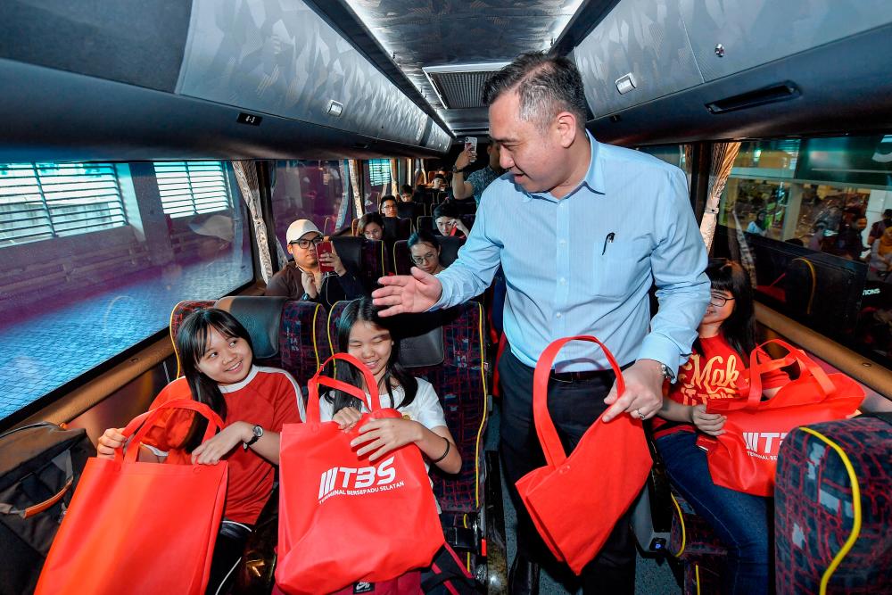 Transport Minister Anthony Loke Siew Fook hands out a souvenirs to the passengers of a bus during a work visit at the Southern Integrated Terminal (TBS) in Kuala Lumpur today. - Bernama