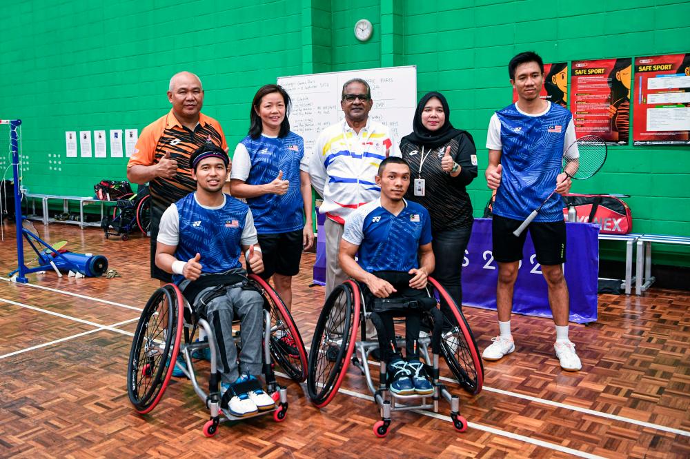 Head of the Malaysian Contingent (CDM) to the Paris Paralympics, Datuk Subramaniam Raman Nair (centre, back) poses with Para Badminton athletes, Muhammad Ikhwan Ramli (right, front) and Noor Azwan Noorlan (left, front) - BERNAMApix