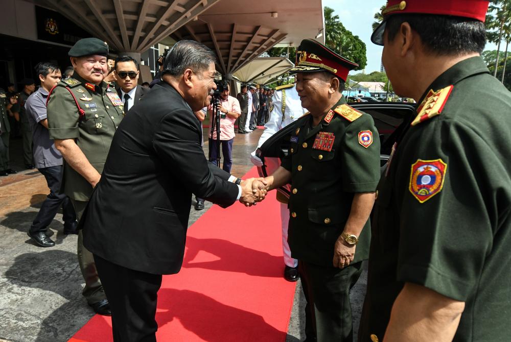 Defence Minister Mohamad Sabu (L) shakes hand with his counterpart from Laos, General Chansamone Chanyalath (2R) at Wisma Perwira, on March 23, 2019. — Bernama