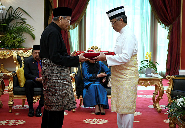 The Yang di-Pertuan Agong, Al-Sultan Abdullah Ri’ayatuddin Al-Mustafa Billah Shah (right) receiving the D.K.M award from Prime Minister Tun Dr Mahathir Mohamad today at the National Palace.
