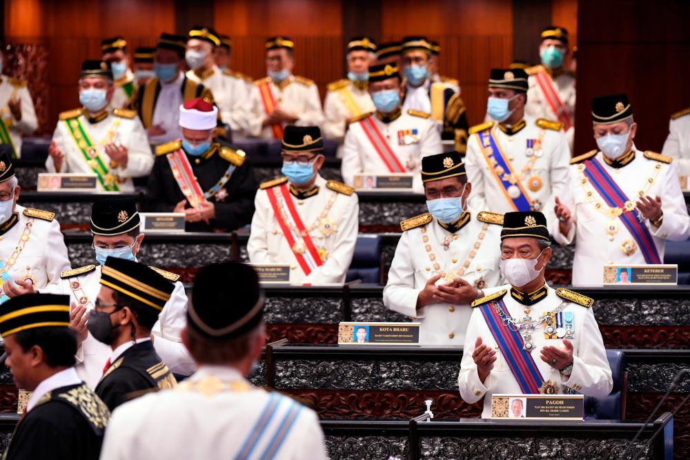 Members of Parliament reciting a prayer at the opening of the Third Session of the 14th Parliament in Parliament Building yesterday. — Bernama