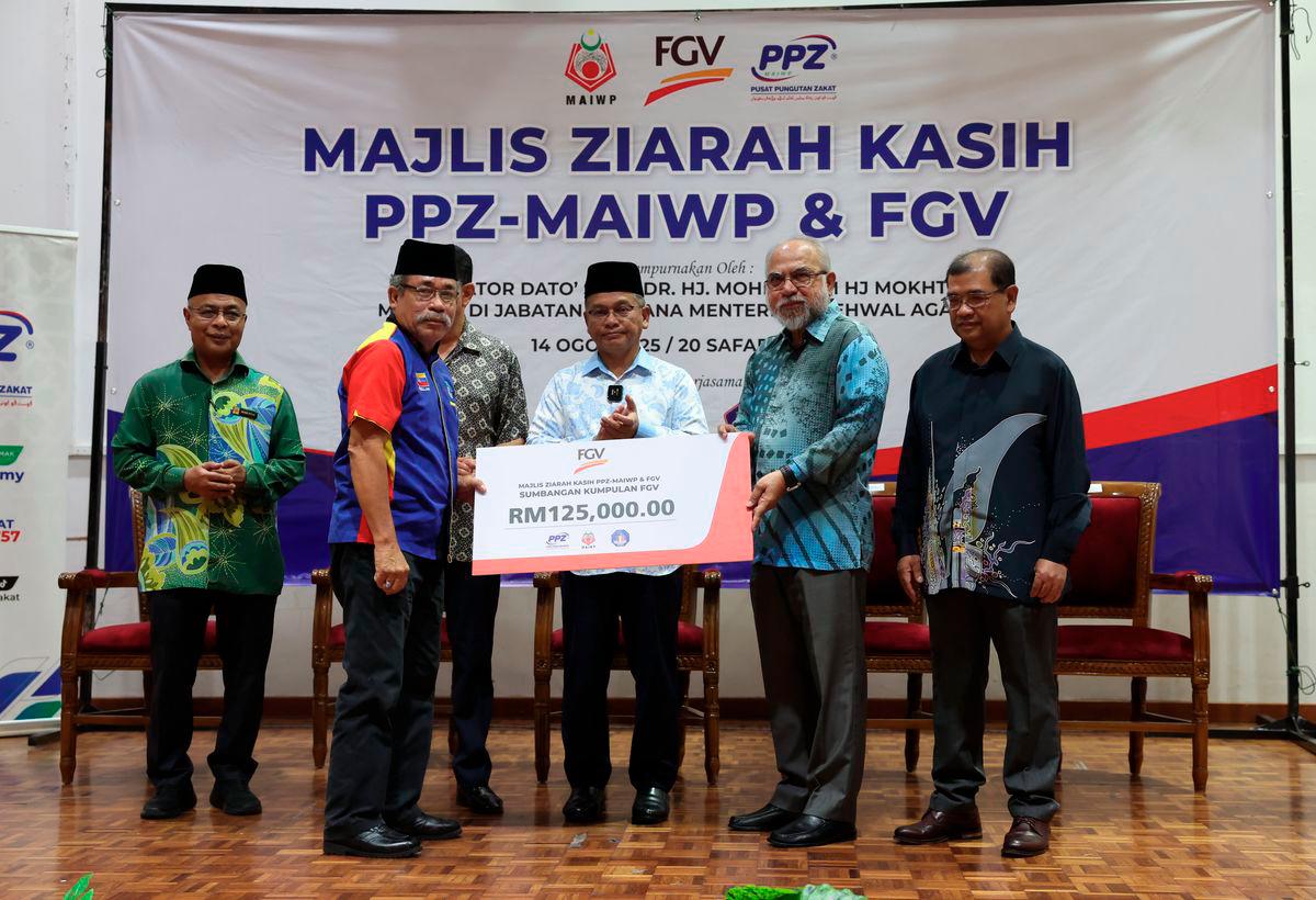 Minister in the Prime Minister’s Department (Religious Affairs) Senator Datuk Dr Mohd Na’im Mokhtar looks on as FGV Holdings Berhad Chairman Tan Sri Rastam Isa (second from right) presents a mock cheque for FGV Holdings Berhad’s wakalah contribution to the Chairman of the PPR Taman Wahyu 2 Residents’ Association, Abdullah Uda Saidi, at the PPZ-MAIWP &amp; FGV Ziarah Kasih event at the Taman Wahyu 2 Community Hall today. – BERNAMA