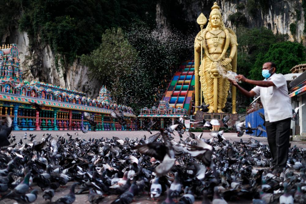 A Hindu man feeding the pigeons at the Sri Subramaniar Swamy temple in Batu Caves that has been closed due to the MCO.--fotoBERNAMA (2021) Copyrights Reserved