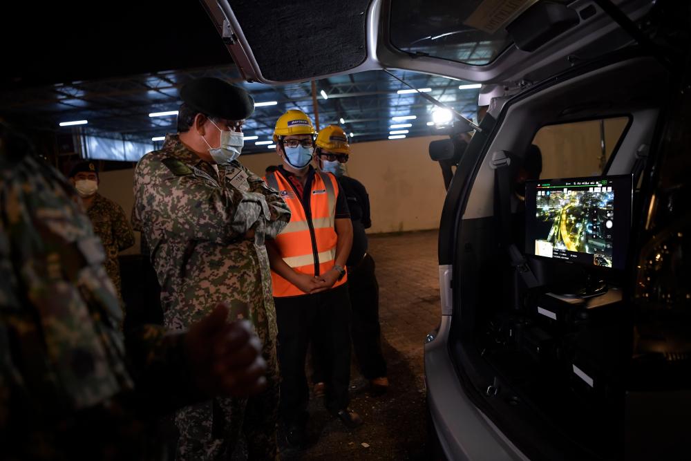 Army Chief Gen Tan Sri Ahmad Hasbullah Mohd Nawawi looks at the screen that projects images from the drone, during the ‘Op Penawar’ , on March 28, 2020. — Bernama