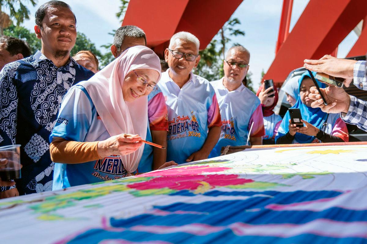 The Prime Minister’s wife and Member of Parliament for Bandar Tun Razak, Datuk Seri Dr Wan Azizah Wan Ismail (second from left), tried her hand at the batik canting activity while visiting the booths at the Opening Ceremony of the Ambang Merdeka Carnival for Bandar Tun Razak Parliament 2025 at the Kuala Lumpur Football Stadium grounds today. - BERNAMA