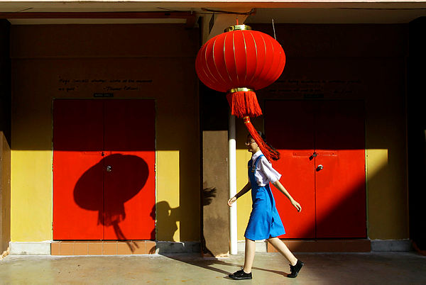 Student, Lim Ai Nee walks in front of a class with decorations for the Chinese New Year celebration, at SMK Pusat Bandar Puchong 1 yesterday. — Bernama