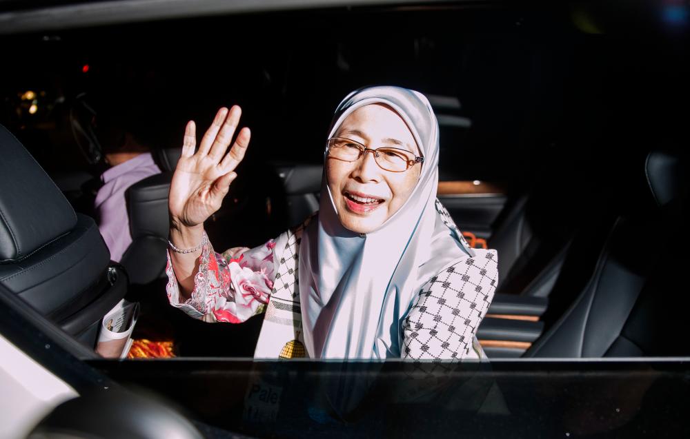 Dr Wan Azizah Wan Ismail waves to the media after attending the Pakatan Harapan presidential council’s emergency meeting at PKR headquarters tonight. - Bernama