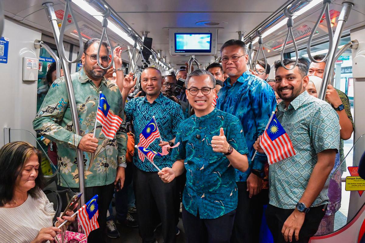 Menteri Komunikasi Datuk Fahmi Fadzil (tiga, kanan) bergambar sempena Program Edaran Jalur Gemilang Sempena Sambutan Hari Kebangsaan di Stesen LRT Bangsar hari ini. Turut hadir Ketua Pegawai Eksekutif Kumpulan Prasarana, Amir Hamdan (dua, kiri) -fotoBERNAMA