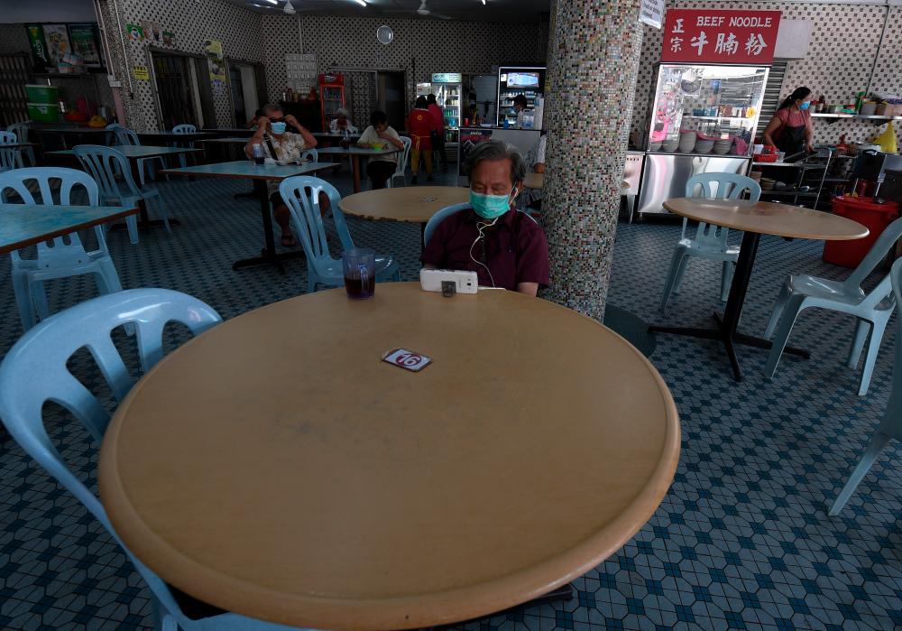 Restaurant customers are seen following the rules of the CMCO after several business and transport sectors were allowed to operate beginning today. - Bernama