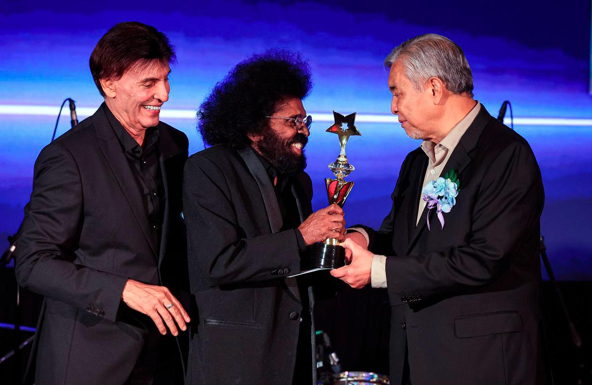 Deputy Prime Minister, Datuk Seri Dr Ahmad Zahid Hamidi, presenting the Singer Icon Award to renowned singer Datuk David Arumugam (second from left) during the *Budi Kasih Malaysia* Concert yesterday. Also present was the Chairman of the National Artistes Welfare Foundation (YKAT), Datuk Irwan Shah Abdullah (left). – BERNAMA