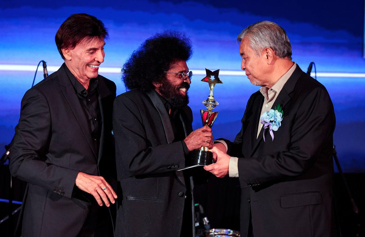 Timbalan Perdana Menteri, Datuk Seri Dr Ahmad Zahid Hamidi ketika menyampaikan anugerah ikon Penyanyi kepada penyanyi terkenal, Datuk David Arumugam (dua, kiri) pada Konsert Budi Kasih Malaysia - fotoBERNAMA
